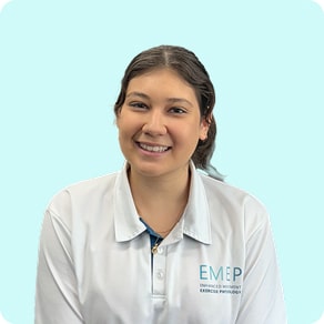 A woman with long dark hair in a ponytail, wearing a white collared shirt with the EMEP logo, smiles at the camera against a light blue background.