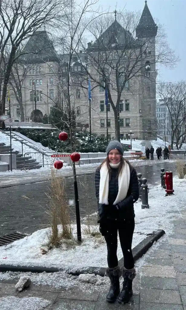 Bailey White, Client Experience Officer at Enhance Movement, smiling in the snow during a trip to Canada.